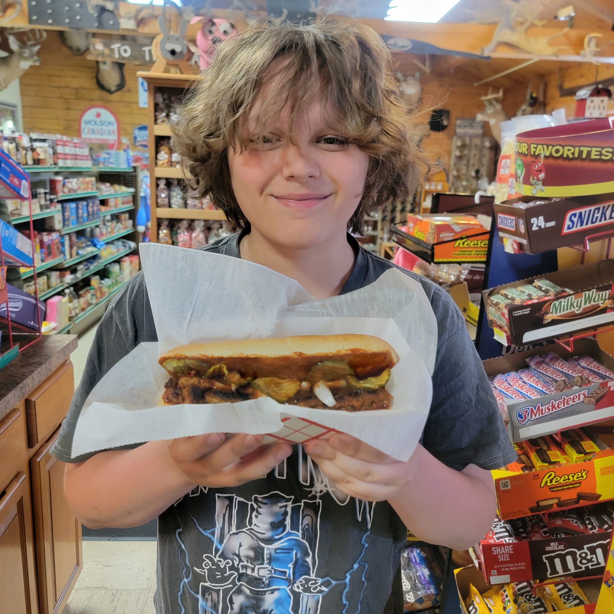 Happy customer showing off a meatball sub in the store